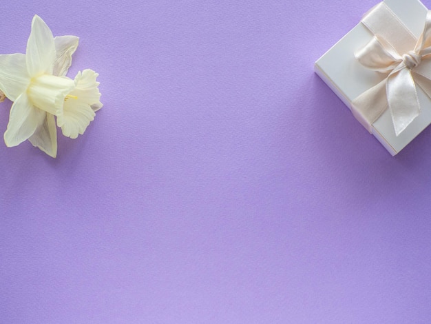 Caja de regalo de flores de narcisos y fondo de papel con espacio de copia