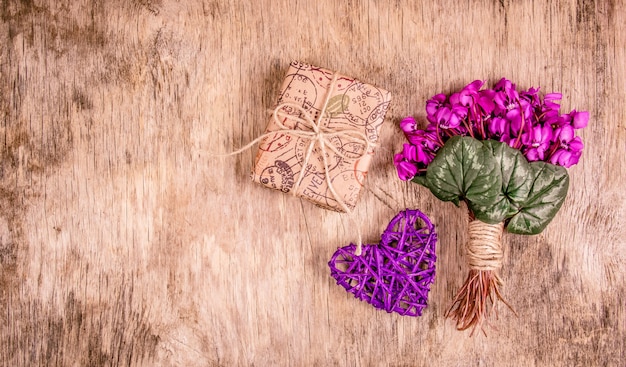 Caja de regalo y flores de primavera, delicadas violetas y corazón.