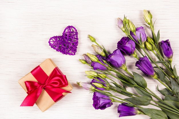 Foto caja de regalo y flores sobre fondo blanco.
