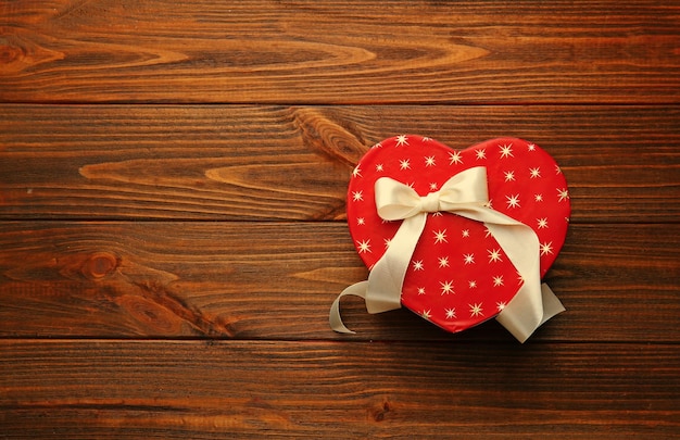 Caja de regalo en forma de corazón en la mesa de madera