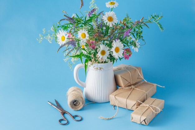 Caja de regalo hecha a mano con flores silvestres sobre fondo azul