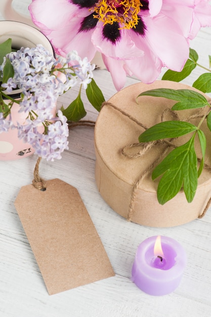 Foto caja de regalo kraft, peonías y flores lilas