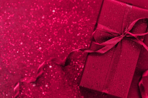 Foto caja de regalo con lazo azul sobre fondo viva magenta concepto festivo color del año 2023