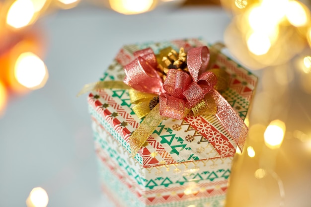 Caja de regalo con un lazo en el fondo del bokeh navideño