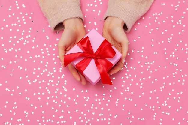 Caja de regalo con lazo en manos de mujer. plano