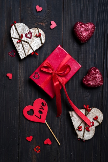 Caja de regalo con lazo rojo y corazón de madera.