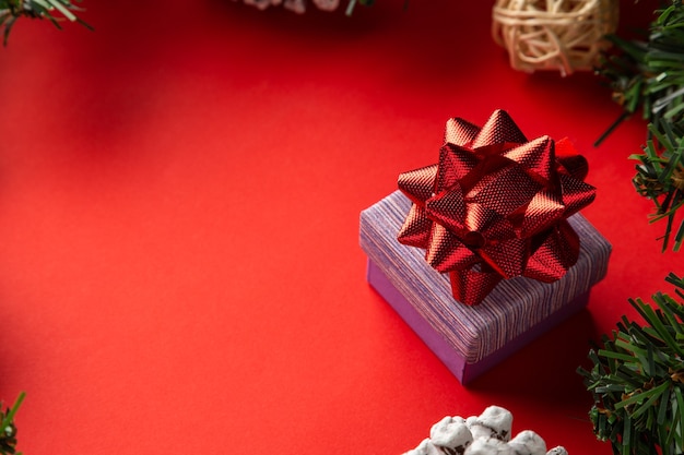 Caja de regalo con un lazo rojo sobre fondo rojo Tema de desembalaje de Navidad