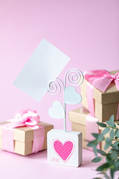 Caja de regalo con un lazo rosa y una tarjeta en blanco.