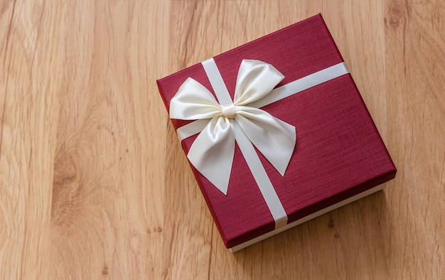 Caja de regalo en madera, lazo de cinta blanca de color burdeos