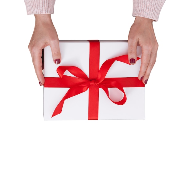 Caja de regalo en manos femeninas aislado en blanco