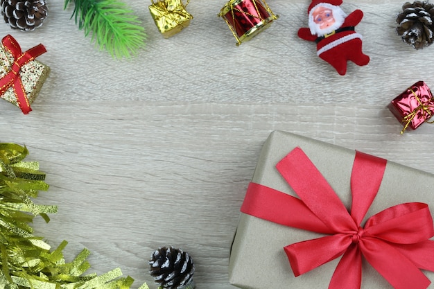 Caja de regalo marrón con lazo rojo en el piso de madera y herramienta de decoración.