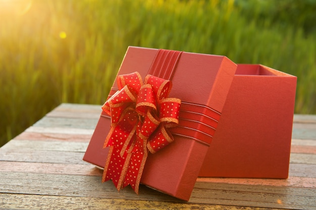 Caja de regalo en la mesa de madera en puesta de sol