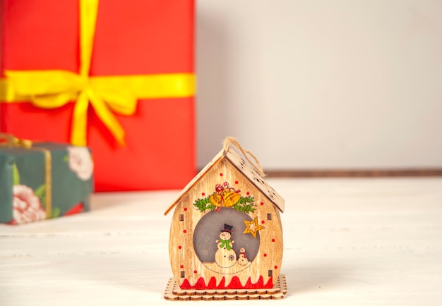 Caja de regalo y modelo de casa en la mesa de madera.