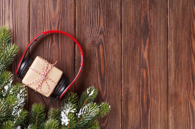 Caja de regalo de Navidad con auriculares y rama de árbol.