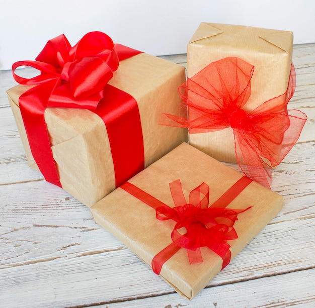 Foto caja de regalo de navidad con cinta roja y rama de abeto en el blanco sobre conos de pino