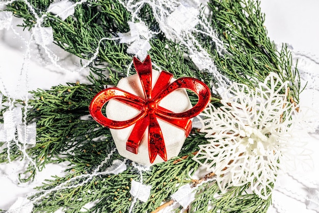 Caja de regalo de Navidad y copo de nieve en una rama de un árbol de coníferas Concepto de año nuevo de Navidad