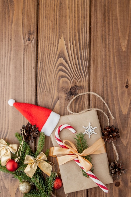 Caja de regalo de Navidad, decoración de alimentos y rama de abeto en mesa de madera. Vista superior con copyspace