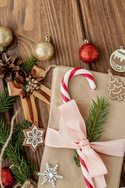 Caja de regalo de Navidad, decoración y rama de abeto en mesa de madera. Vista superior con copyspace