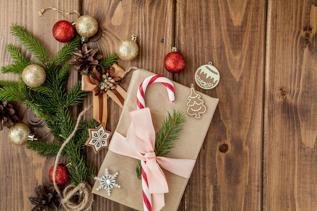 Caja de regalo de Navidad, decoración y rama de abeto en mesa de madera.