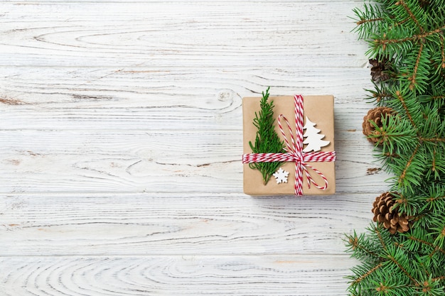 Caja de regalo de Navidad envuelta en papel reciclado, con lazo de cinta, con cinta sobre fondo rústico. Vacaciones