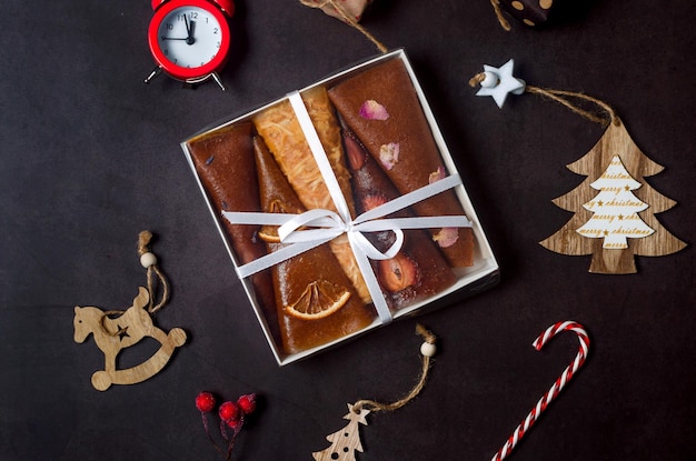 Caja de regalo de navidad con frutos secos y decoraciones en la oscuridad.