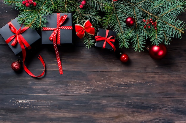 Caja de regalo de Navidad negra con cinta roja y ramas de abeto