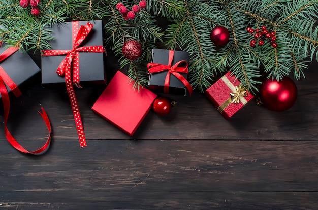 Caja de regalo de navidad negra y roja con cinta roja y ramas de abeto