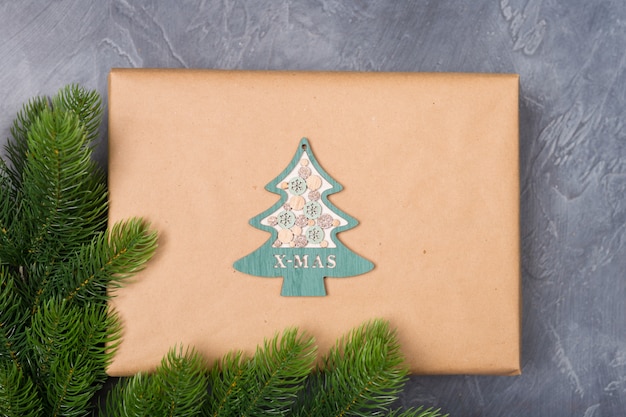 Caja de regalo de Navidad en papel artesanal con decoración de árbol de madera sobre fondo oscuro con piel. Año nuevo concepto de Navidad.