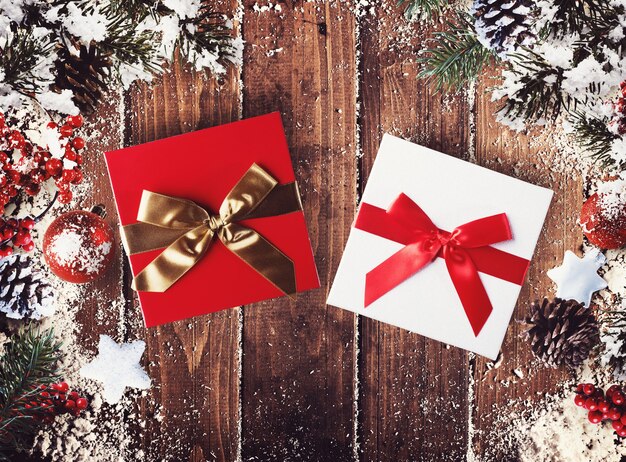 Caja de regalo de Navidad presentada en medio de adornos navideños sobre tablas de madera