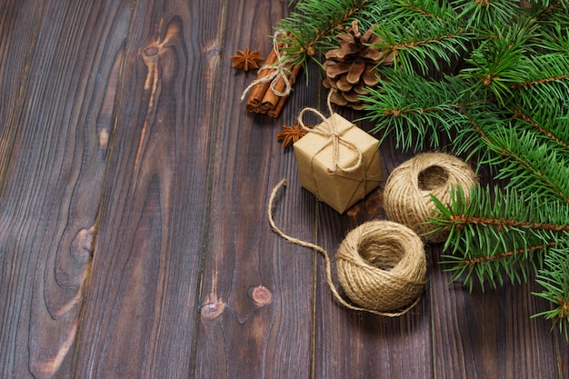 Caja de regalo de Navidad y ramas de abeto con canela y anís en madera rústica,