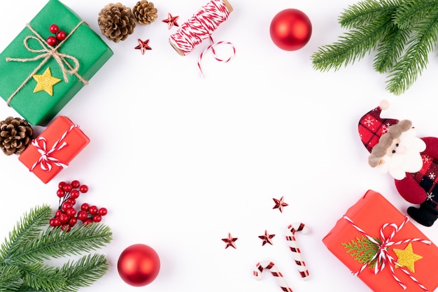 Caja de regalo de la Navidad con las ramas spruce, conos del pino, bayas rojas en el fondo blanco.