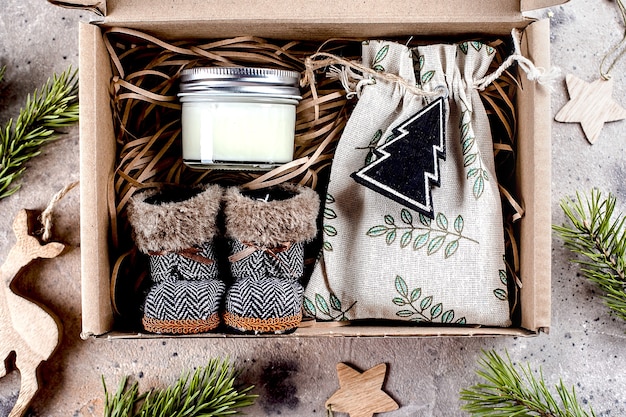 Caja regalo navideña con bolsa textil para abrazar artículos, vela y botitas. Concepto de paquete de cuidado. Vista superior, endecha plana