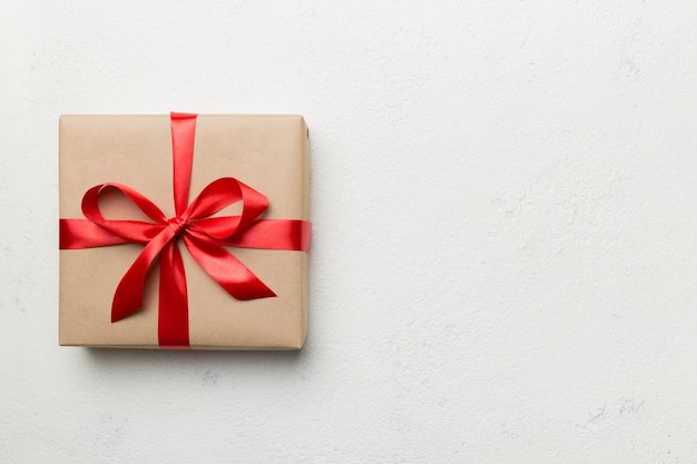 Caja de regalo navideña envuelta en papel artesanal con lazo de color en el fondo de la mesa Vista superior espacio de copia plana