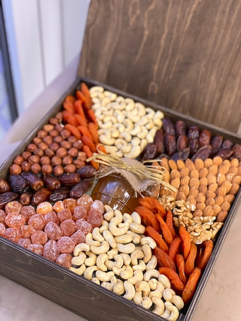 Una caja de regalo con nueces, frutos secos y miel. Caja de madera con comida