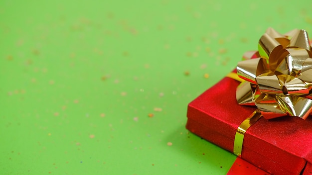 Caja de regalo o presente y confeti en backgraund rojo y verde. Composición plana para navidad