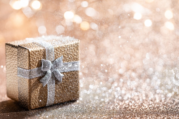 Caja de regalo de oro con luz mágica en brillo bokeh para vacaciones de Navidad.