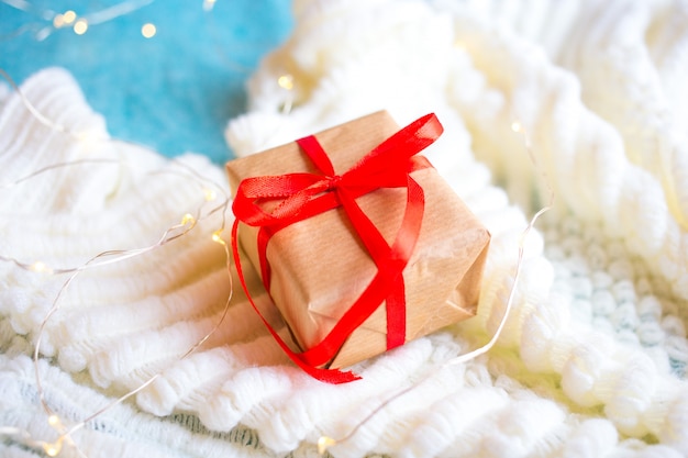 Caja con un regalo con papel artesanal en blanco