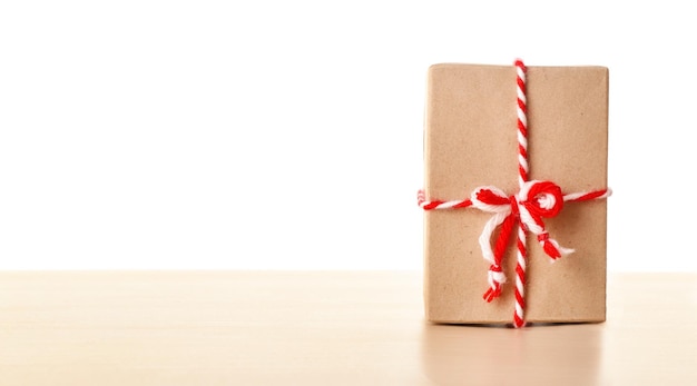 Caja de regalo de paquetería en la mesa con fondo blanco.