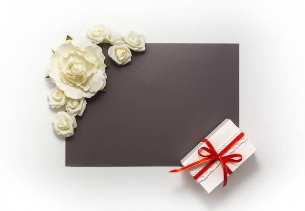 Caja de regalo presente decoraciones flatlay. Regalo cinta roja flores blancas vista superior.