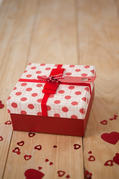 Caja de regalo rodeada de corazón rojo.