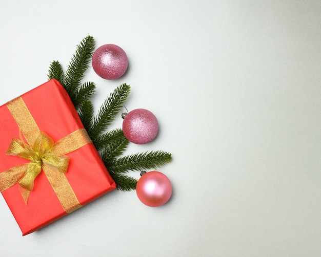 Caja de regalo roja atada con cinta sobre un fondo gris, vista superior. Telón de fondo festivo, espacio de copia