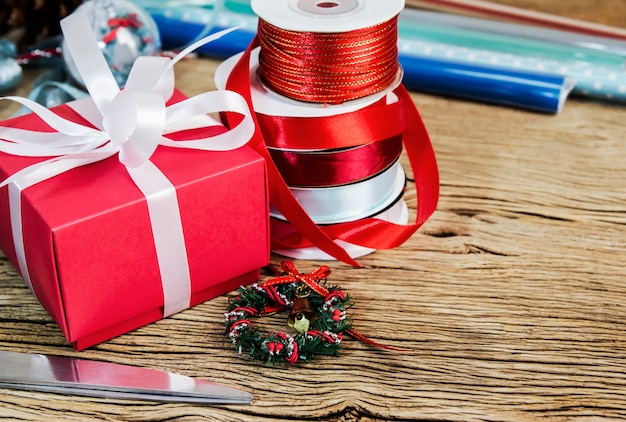 Caja de regalo roja y cinta en la mesa de madera