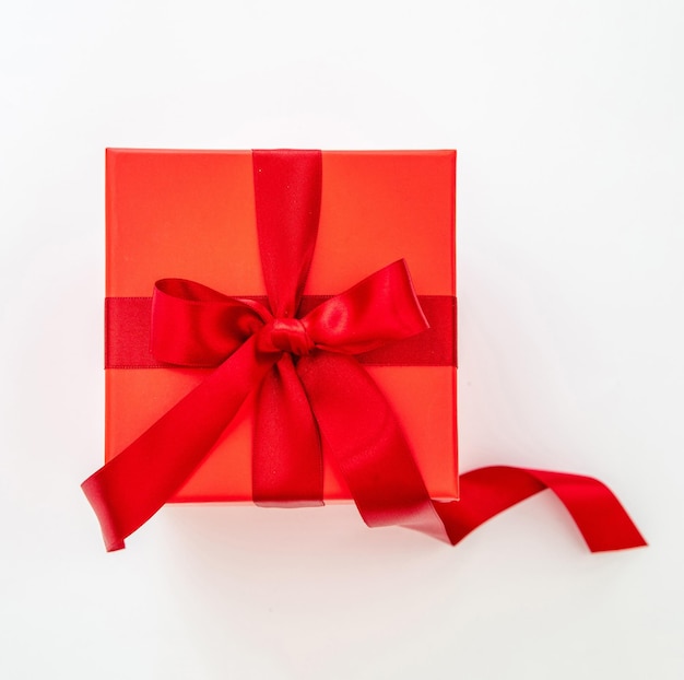 Caja de regalo roja con cinta de pasión roja recortada aislada en la vista superior de fondo blanco