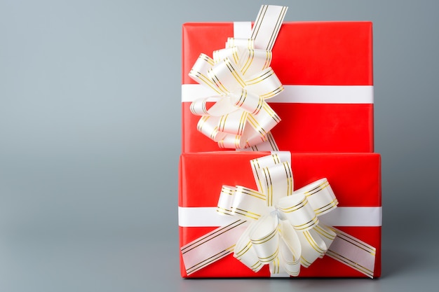 Caja de regalo roja dos con una cinta blanca y un lazo