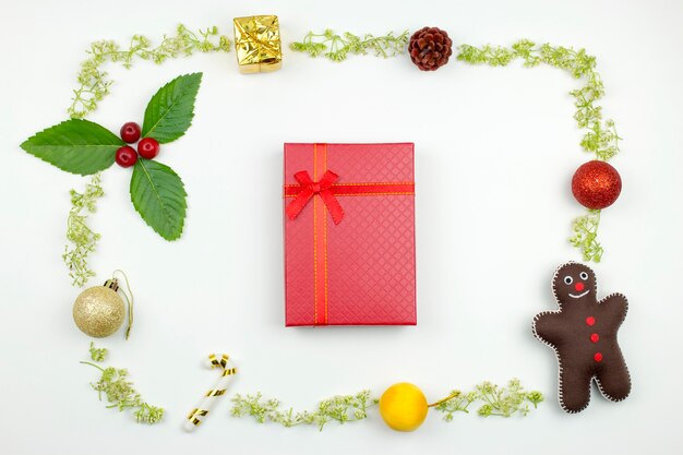 Una caja de regalo roja con marco de decoración de Navidad. Flat lay Christmas concept.