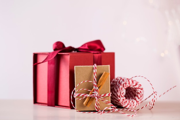 Caja de regalo roja y paquete con ramas de canela y cuerda colorida para vacaciones de Navidad