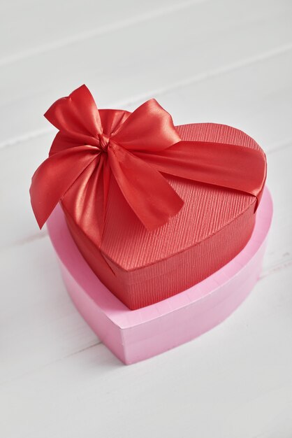 Foto caja de regalo roja y rosa con mesa blanca