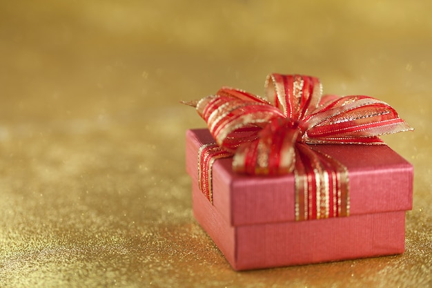 caja de regalo roja sobre fondo de oro brillo