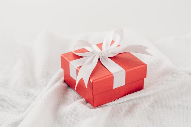 Foto caja de regalo roja sobre un fondo de toalla blanca