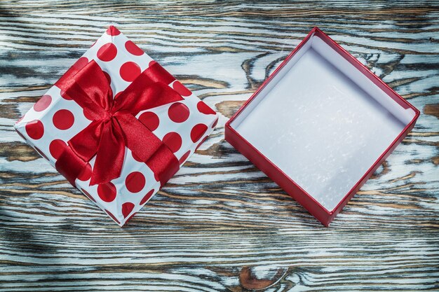 Caja de regalo roja vacía en tablero de madera vintage